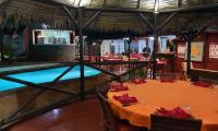 un restaurant avec une piscine et une table avec des serviettes rouges dans l&#39;établissement Clair de Lune, à Ambatoloaka