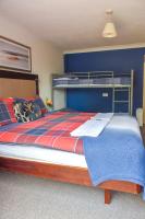 a bedroom with a bunk bed with a blue wall at Gatwick Castle B&B in Horley