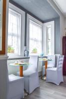 a dining room with two tables and chairs and windows at Gatwick Castle B&B in Horley