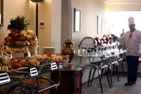 a buffet line with food and a chef in the background at The Convention Center & Royal Suites Hotel in Kuwait