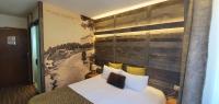 a bedroom with a bed with a large wooden wall at Le Grand Tétras in Font-Romeu
