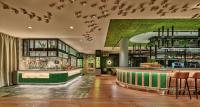 um bar num restaurante com uma parede verde em voco The Hague by IHG em Haia