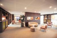 a lobby with a chair and a table and chairs at Fjelsted Skov Hotel &amp; Konference in Ejby