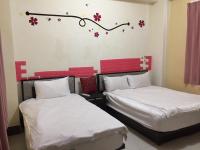 two beds in a room with flowers on the wall at Guanshan Fukuda Homestay in Guanshan