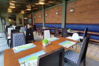 een eetkamer met houten tafels en stoelen bij R-Mar Resort and Spa Patong, Phuket in Patong Beach