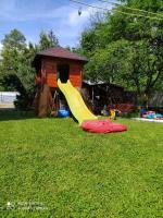 a slide on the grass in front of a house at Guest house Shulc in Mizhhirya