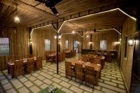 Un comedor con mesas y sillas de madera. en Gold Nest Rubystone Heritage, en Udaipur