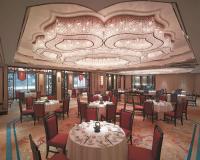 a dining room with tables and chairs and a large chandelier at Shangri-La Bangkok in Bangkok