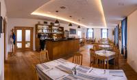 a restaurant with tables and chairs and a bar at Hotel Poutní Dům in Králíky