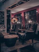 a bar with leather chairs and a table in a room at Boutique Hotel Schulz Classic in Neustadt am Rübenberge