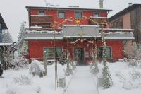 Un edificio rojo con nieve delante. en Jolly Residence, en Bormio