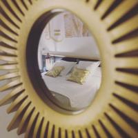 a mirror reflecting a bed in a bedroom at Hostellerie LE PANEL in Mandelieu-La Napoule
