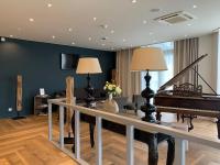 a living room with a piano and a couch at Saint Georges Hotel &amp; Spa in Chalon-sur-Saône