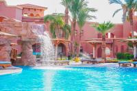 a swimming pool with a waterfall in a resort at Charmillion Gardens Aquapark in Sharm El Sheikh