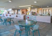 a restaurant with tables and chairs and a kitchen at Charmillion Gardens Aquapark in Sharm El Sheikh