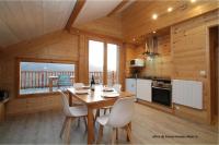 a kitchen and dining room with a table and chairs at La Rawette in Puy-Sanières