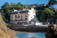 a building on the shore of a body of water at Hôtel De La Vallée in Dinard