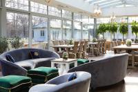 a restaurant with blue chairs and tables and windows at Farma Bii in Brzeziny