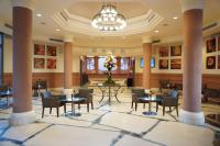 a lobby with tables and chairs and a chandelier at Charmillion Gardens Aquapark in Sharm El Sheikh