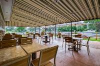 un restaurante vacío con mesas, sillas y sombrillas en Best Western Plus Windjammer Inn & Conference Center, en Burlington