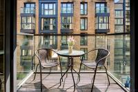 a table and two chairs on a balcony with a building at City View Apartments Birmingham City Centre in Birmingham