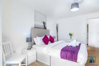 a white bedroom with a large bed with pink pillows at City View Apartments Birmingham City Centre in Birmingham