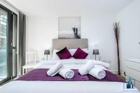 a bedroom with a large white bed with purple pillows at City View Apartments Birmingham City Centre in Birmingham