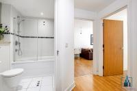 a white bathroom with a shower and a toilet at City View Apartments Birmingham City Centre in Birmingham