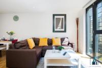 a living room with a brown couch and yellow pillows at City View Apartments Birmingham City Centre in Birmingham