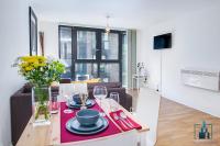 a kitchen and living room with a table with plates and wine glasses at City View Apartments Birmingham City Centre in Birmingham