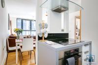 a white kitchen with a stove top oven next to a table at City View Apartments Birmingham City Centre in Birmingham