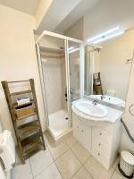 a white bathroom with a sink and a shower at Charmant T2 À 50m de locéan in Ploemeur