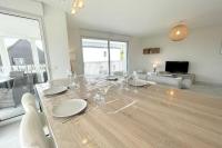 a dining room with a table with glasses on it at Spacieux appartement neuf de standing Hyper Cosy in Larmor-Plage