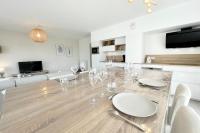 a dining room with a table with wine glasses on it at Spacieux appartement neuf de standing Hyper Cosy in Larmor-Plage