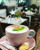 uma xícara de café num prato com uma folha em cima em Gosciniec Pod Brzozami em Poznań