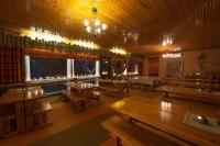 a dining room with wooden tables in a restaurant at Hotel Hetan Majatalo in Enontekiö