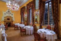 a dining room with tables and chairs and a chandelier at Sofitel Winter Palace Luxor in Luxor