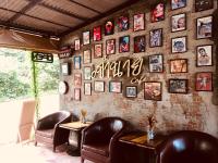 阁帕延岛Phayam Valley Homestay的一家餐厅，里面有皮椅和一面挂满照片的墙。