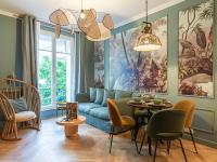 a living room with a blue couch and a table at Nature and Haven of Peace Apartment in Paris