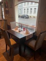 a table with chairs and a car outside a window at Pension Villa Colosseo im Herzen von Meiningen in Meiningen
