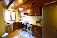 a kitchen with a refrigerator and a washer and dryer at Duplex el Pla de la Tour in Latour-de-Carol