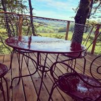 a table and chairs on a wooden deck with rain on it at Le monde d&#39;Echozellia in Saint-Germain-des-Champs