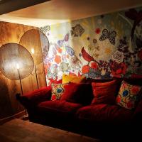 a couch in a living room with a wall with butterflies at Le monde d&#39;Echozellia in Saint-Germain-des-Champs