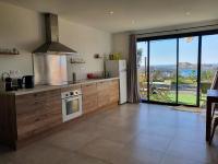 a kitchen with a stove and a large window at Romane in LʼÎle-Rousse