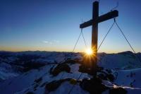 a cross on the top of a mountain with the sunset at Haus Staud in Schmirn