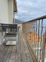 a bench sitting on a wooden balcony overlooking the ocean at CASA GUASCO superbe duplex au cœur de la Citadelle, vue à 360 in Bastia