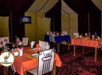une salle à manger avec tables et chaises et une pièce avec tables et chaisesktop dans l'établissement Your magic camp, à Merzouga