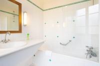 a white bathroom with a tub and a sink at HOTEL DU PRINTEMPS in Paris