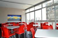 a dining room with tables and red chairs at Hotel Block Suites in Mexico City