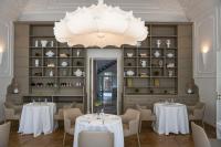 a dining room with tables and chairs and a chandelier at Dimora Palanca Boutique & SPA in Florence